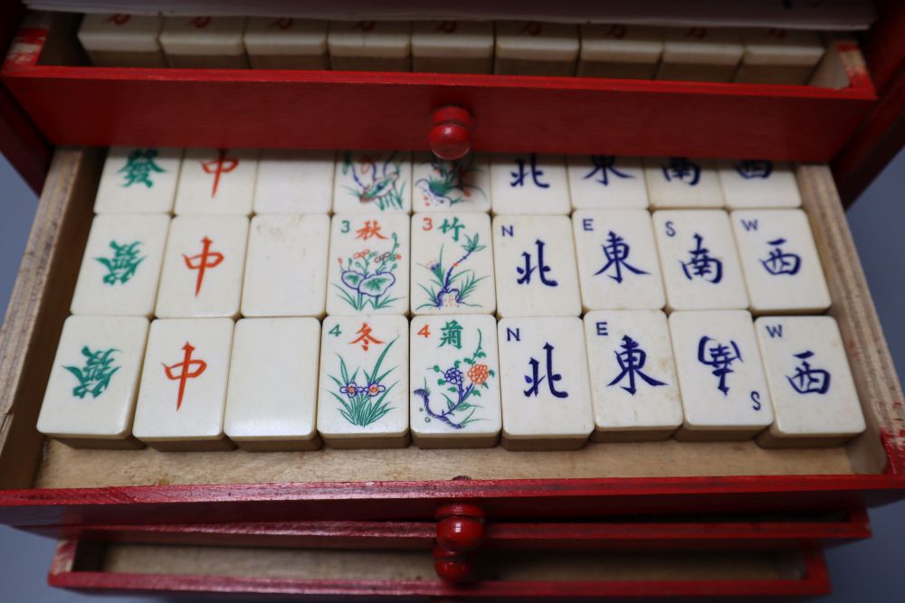 A Mah Jong set in red stained wood case